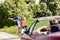 Couple hitchhiking and stopping car on countryside