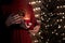 Couple hold and open a red Christmas gift box with magical lights