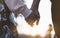 Couple holding for hands on the beach on background ocean sunrise flare, silhouette two romantic people looking on rear view