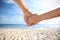 Couple holding hands on beach, closeup