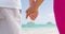 Couple holding hands on beach in love on travel vacation honeymoon