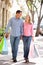 Couple holding hands carrying shopping