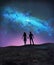 Couple holding hands looking Milky Way galaxy stars