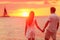 Couple holding hands together at beach sunset