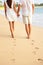 Couple holding hands walking on beach on vacation