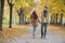 Couple holding hands while walking in park during autumn