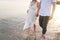 Couple holding hands walking romantic on beach on vacation travel holidays