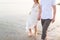 Couple holding hands walking romantic on beach on vacation travel holidays