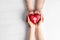 Couple holding heart with cross symbol on background, top view. Christian religion