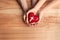 Couple holding heart with cross symbol on background, top view. Christian religion