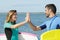 couple holding surfboards doing high five