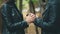 Couple is holding and warming up hands during cold autumn day. Close up. Blurred background. Crop. 4K.