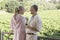 Couple Holding Wine Glasses In Front Of Vineyard