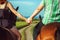 Couple on horseback holding hands