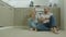 Couple with hot drinks sitting on kitchen floor