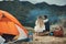 Couple, hug and relax on mountain camping, adventure or travel in nature and environment. People, tent and bonding