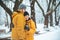 couple hug in winter snowed park. drinking coffee to go to warm up in cold day