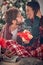 Couple hugging around christmas tree at home