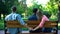 Couple hugging on bench, woman secretly holding hand of other man, betrayal