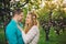 Couple hugging and kissing in cherry wood at sunset