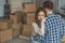 couple hugging at new apartment full of cardboard boxes, moving