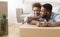 Couple Hugging Sitting On Floor Among Boxes In New Apartment