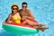 Couple with inflatable ring in swimming pool. Summer vacation