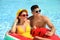 Couple with inflatable ring in swimming pool. Summer vacation