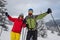 Couple of joyful travelers in goggles stands at alpine meadow