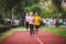 Couple of kids boy and girl doing cardio workout, jogging in park on jogging track red. Cute twins runing together. Run children,