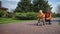 Couple of kids playing with bike outdoor. Elder brother pushing boy on cycle