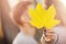 Couple kisses and closes with maple yellow leaf in autumn park, romantic happy date. Concept of love, relationship