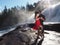 Couple kissing and dancing in a park with a waterfall on the background under the sunlight