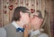 Couple kissing each other against heart drawn on wooden background