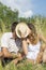 Couple kissing in the field behind hat