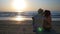 Couple kissing on sandy beach at sunrise