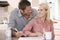 Couple in kitchen with newspaper with coffee