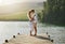 Couple, lake and engagement announcement of young people in love in nature. Happy, relax and hug of a woman and man