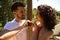 Couple of latin lovers leaning on a wooden poster forming a heart with their hands. The man is camouflaging the woman to make her