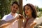 couple of latin lovers leaning on a wooden poster forming a heart with their hands. The man is camouflaging the woman to make her