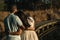 Couple looking backwards embracing each other while sunset coming. Wetland background