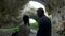 Couple looking at a big cave in the mountains