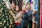 Couple Looking At Christmas Tree While Parents