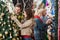 Couple Looking At Christmas Tree With Parents In