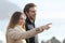 Couple looking forward on the beach and pointing