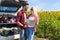 Couple looking road map standing sunflowers field outdoor