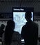 Couple Looking at Subway Information Digital Screen for Directions on NYC Subway Map MTA Train Station