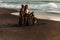 A couple in love on the beach meets the sunset. Beautiful couple on a motorbike meets sunset by the sea.