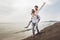 Couple in love on beach summer vacations. Joyful girl piggybacking on young boyfriend having fun