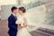 Couple in love bride and groom embrace on a background of urban architecture. The bride\'s veil fluttering in the wind